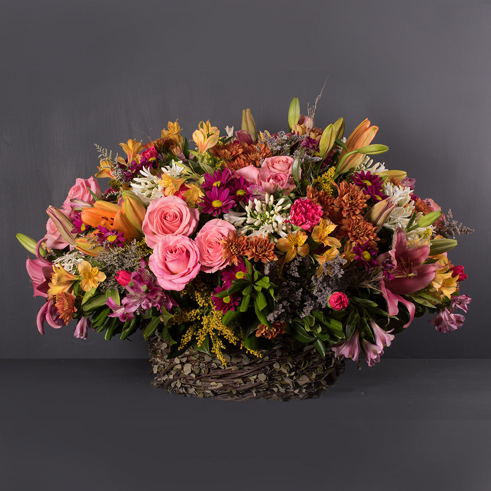 Canasta hecha a mano con 36 rosas, 10 ilis, astromelias, flores de campo, solidago y caspia. A domicilio en CDMX.