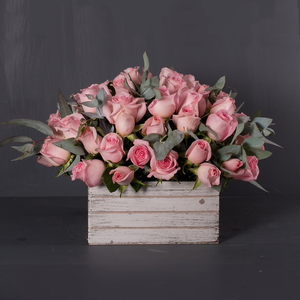 Caja de madera blanca vintage con 48 rosas rosa y eucalipto. A domicilio en CDMX.