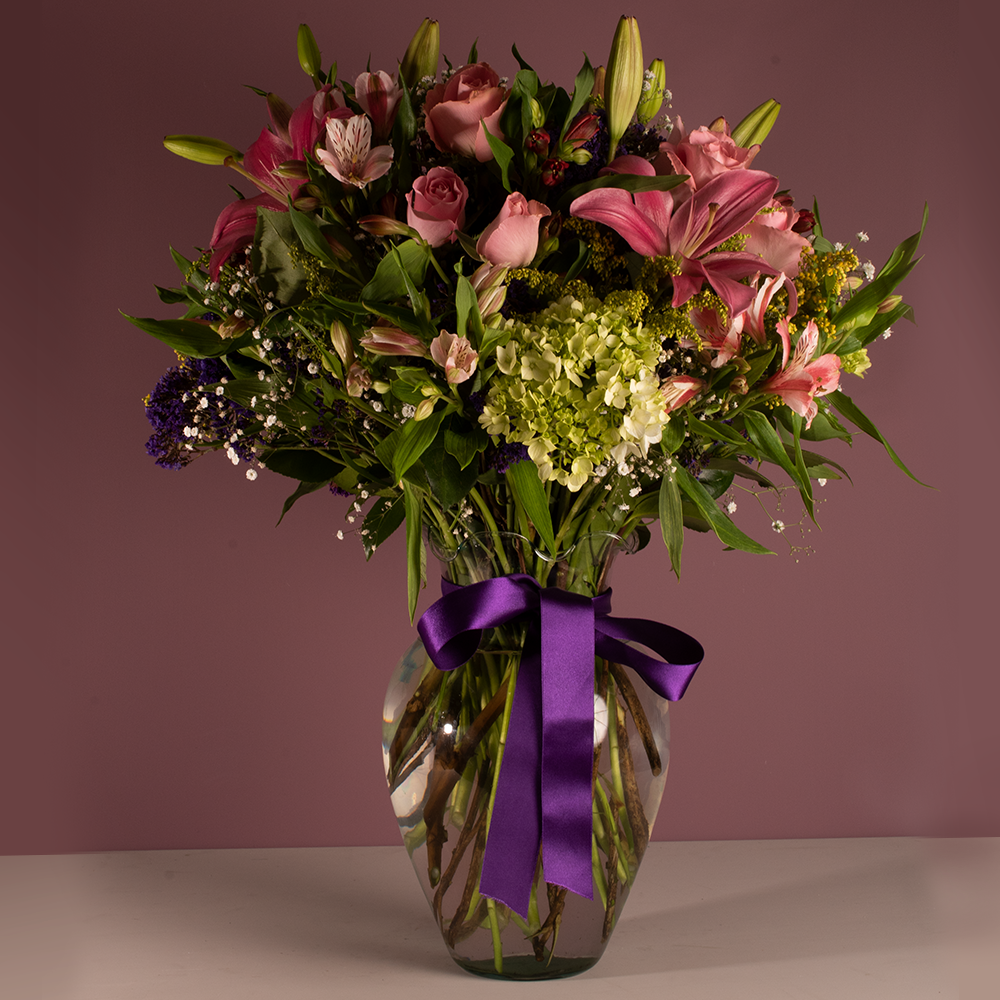 Florero de vidrio con 18 rosas rosa, lili vino, astromelia rosa, hortensia verde, astromelia fucsia con solidago. A domicilio en CDMX. 